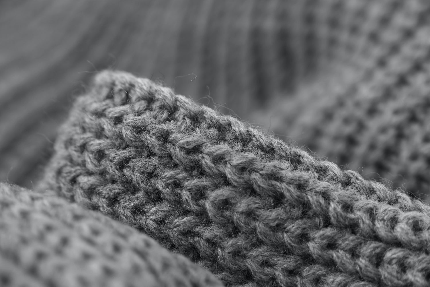 Close-up of textured gray knitted fabric with visible yarn fibers and stitches